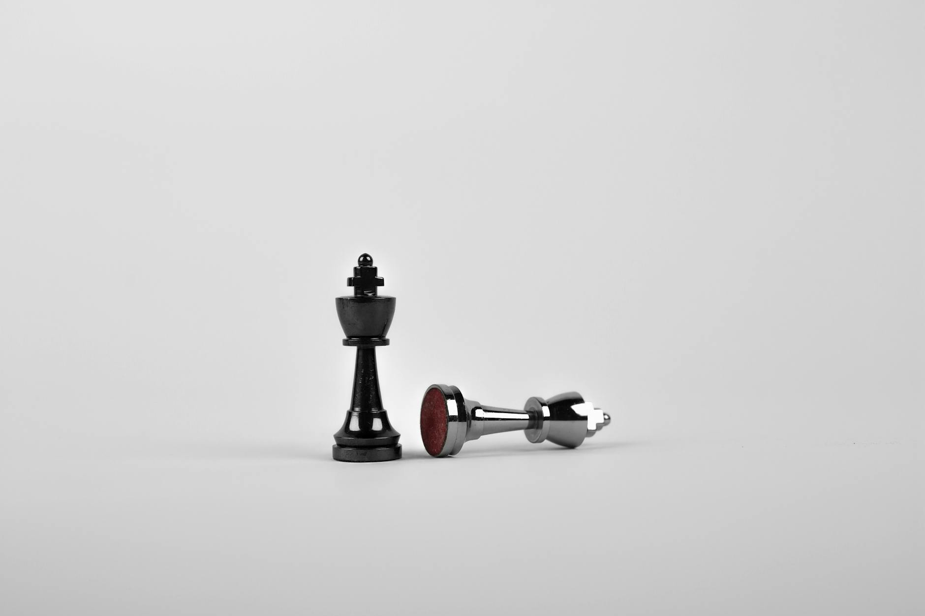 two silver chess pieces on white surface